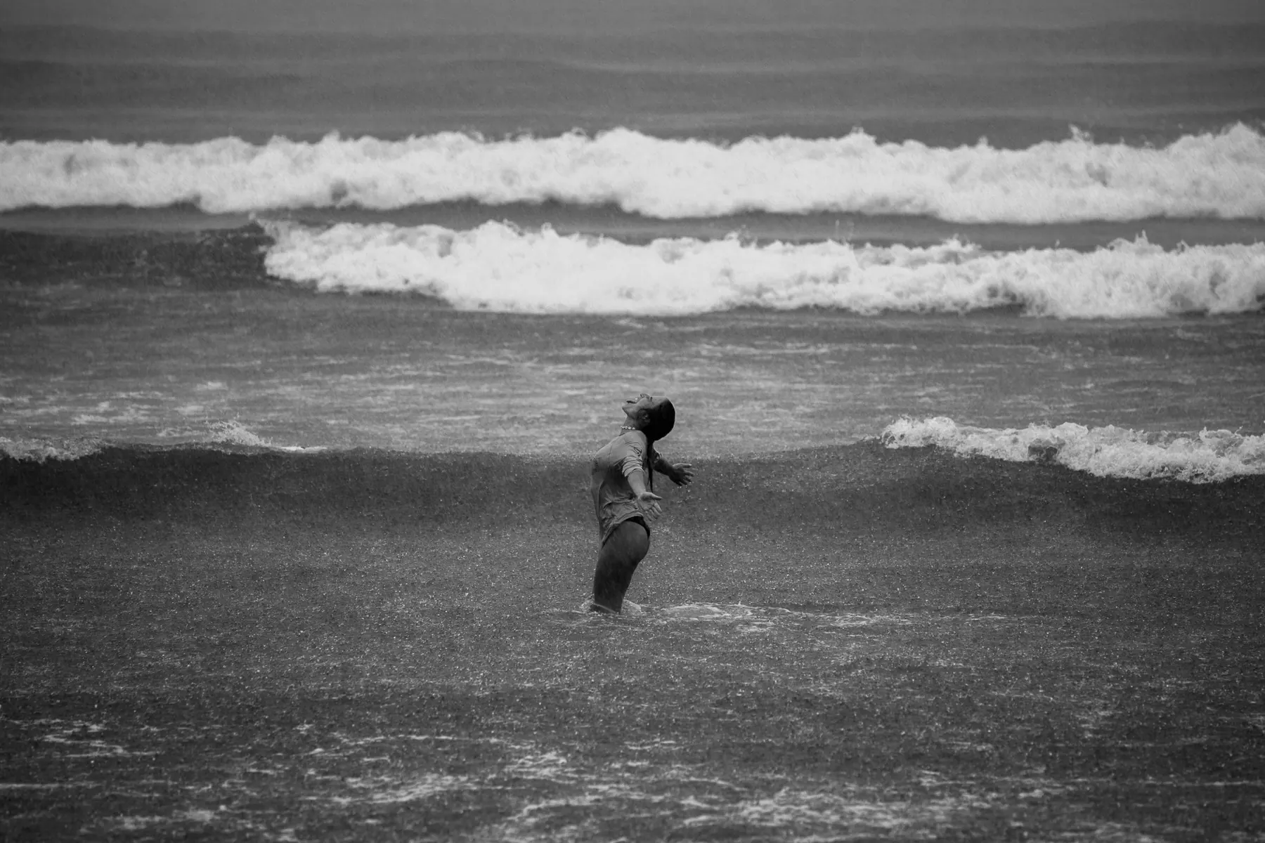 Evelyne in the sea during heavy rain, black and white
